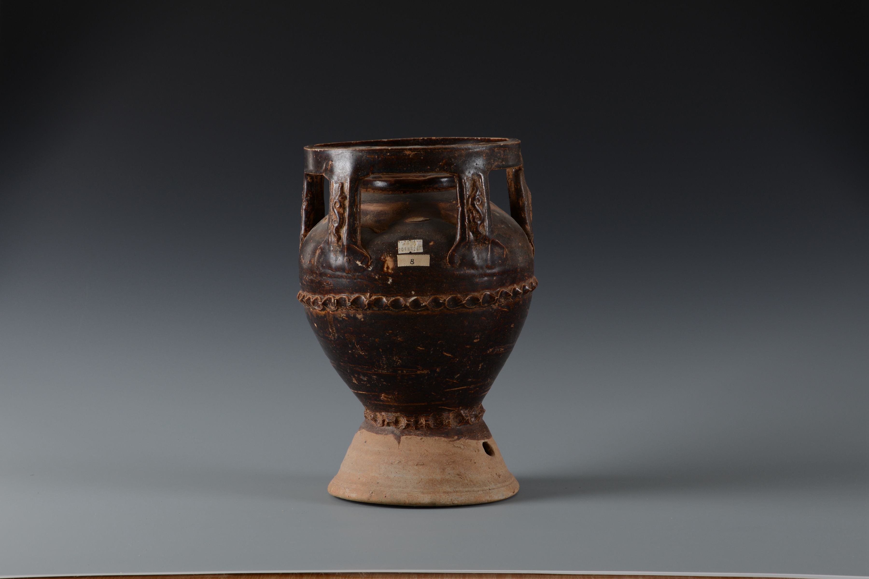 唐醬釉貼塑波浪弦紋陶魂罈